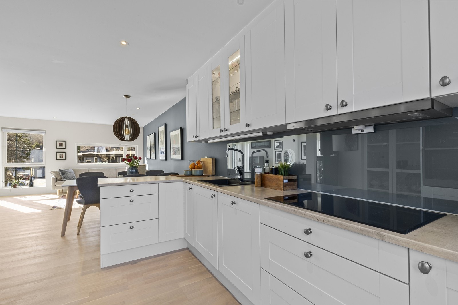 Moderne kjøkken med integrerte hvitevarer og en åpen tilknytning til stue og spiseplass Galleribilde