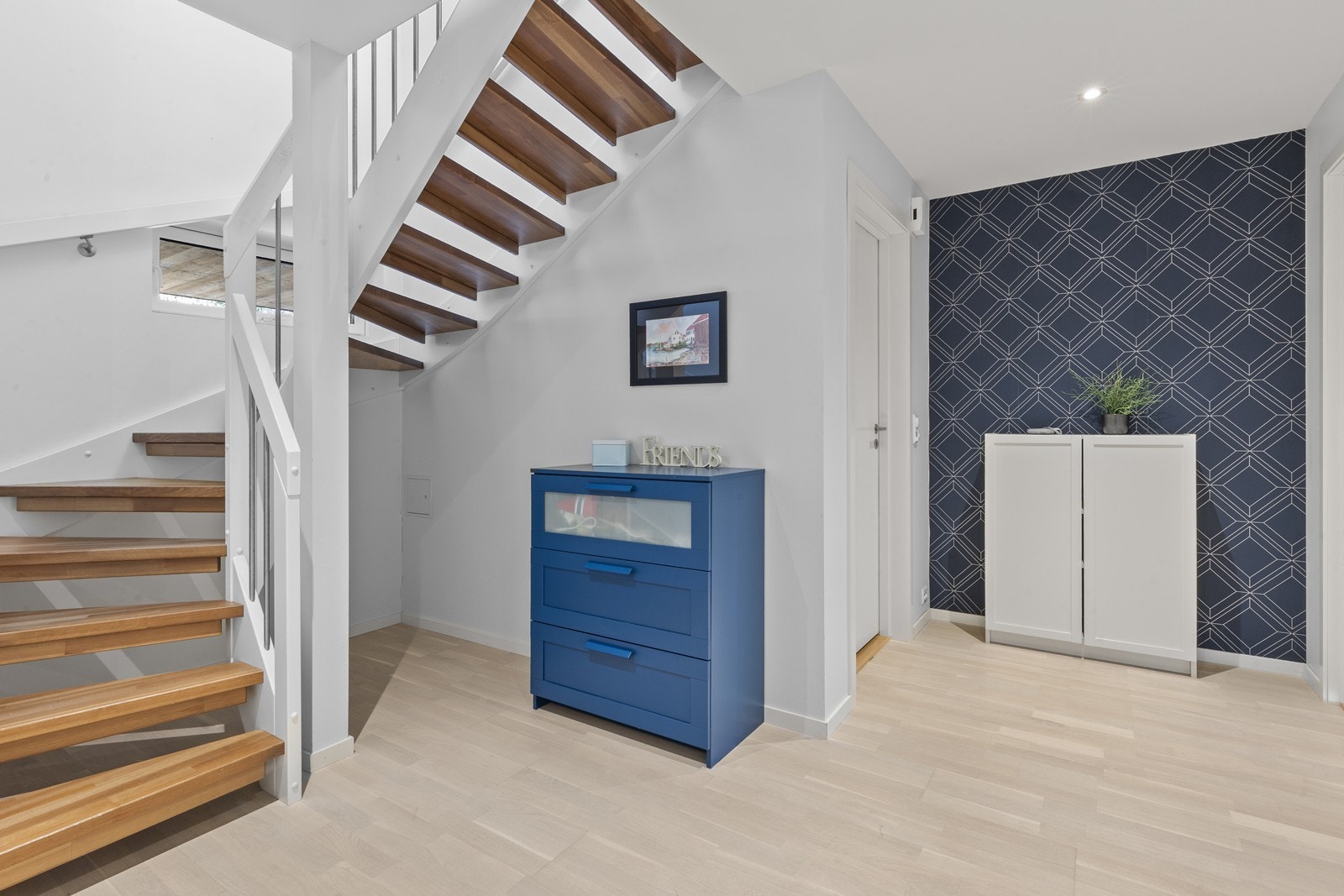 Innbydende mellomgang med trappeløp, oppbevarings muligheter og stilrene overflater Galleribilde