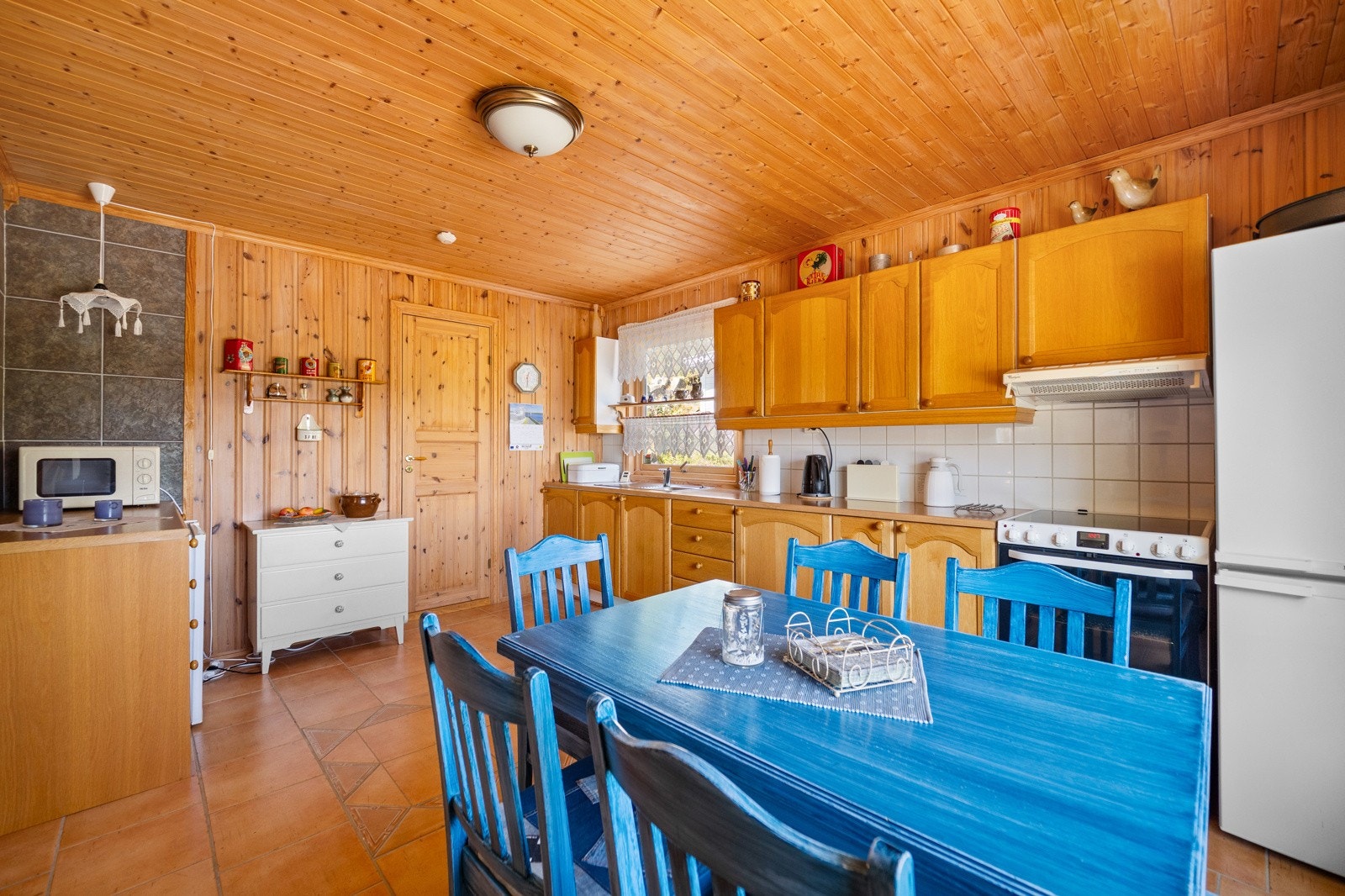 Fliser mellom kjøkkenbenk og overskap. Ventilator i overskap. Galleribilde