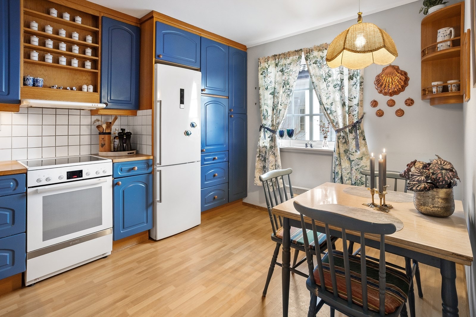 Kjøkkeninnredningen er i malt, profilert utførelse. Benkeplate i laminat med fliser over benk. Galleribilde