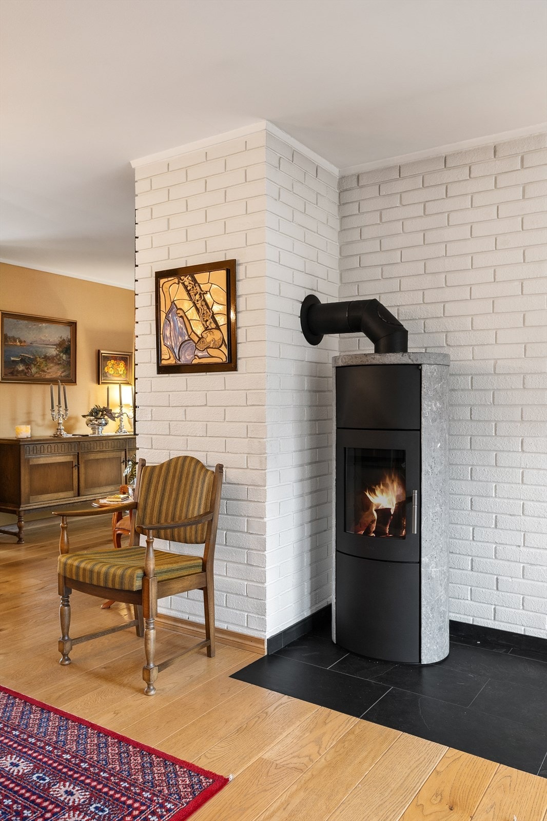 Vedfyrt peisovn i stuen, der er også montert en varmepumpe i trappegangen. Galleribilde