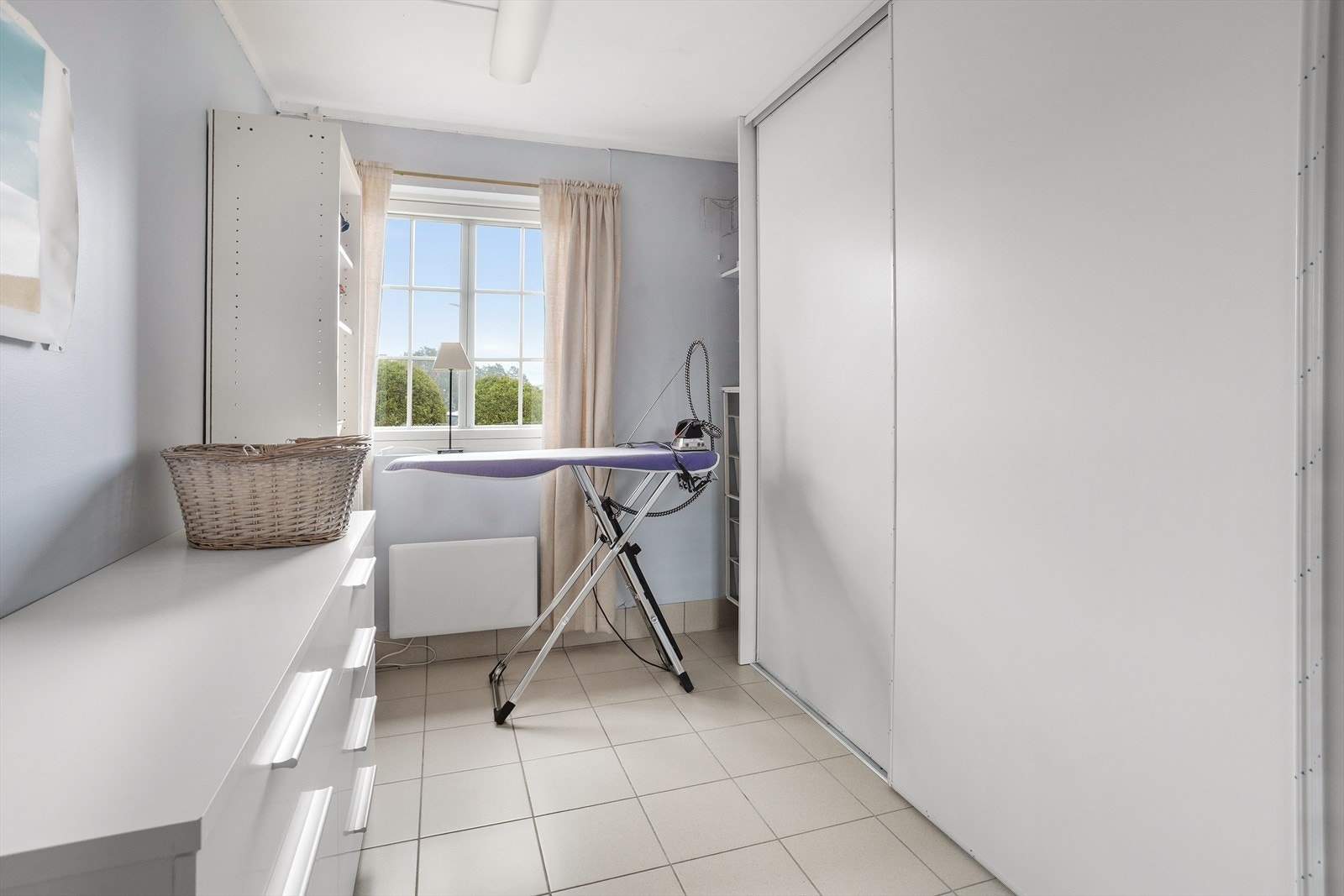 Flott vaskerom med fliser på gulv og godt med oppbevaringsplass. Galleribilde