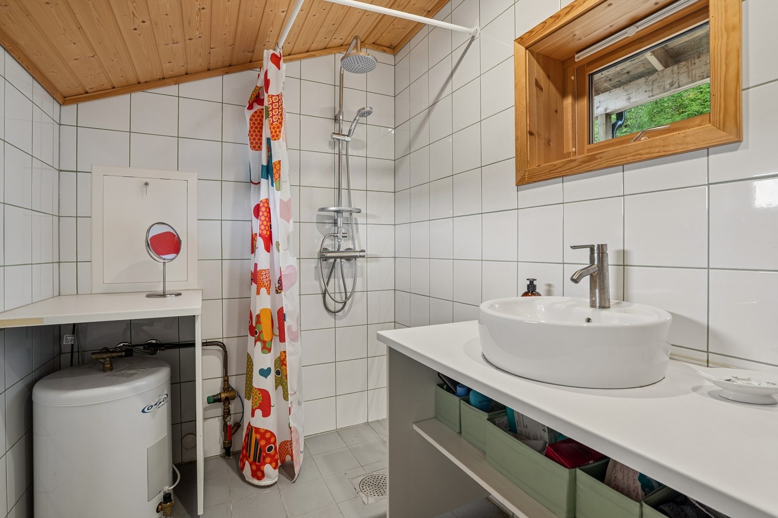 Baderom med dusjhjørne og treverk rundt vindu. Galleribilde