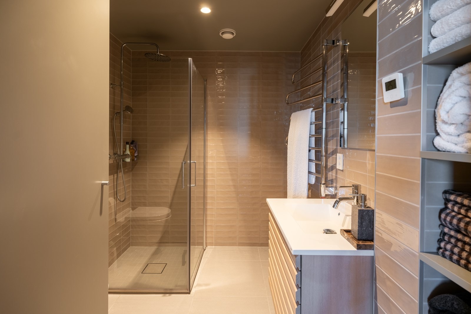 Moderne baderomsinnredning med god oppbevaringsplass og en praktisk håndkletørker. Galleribilde