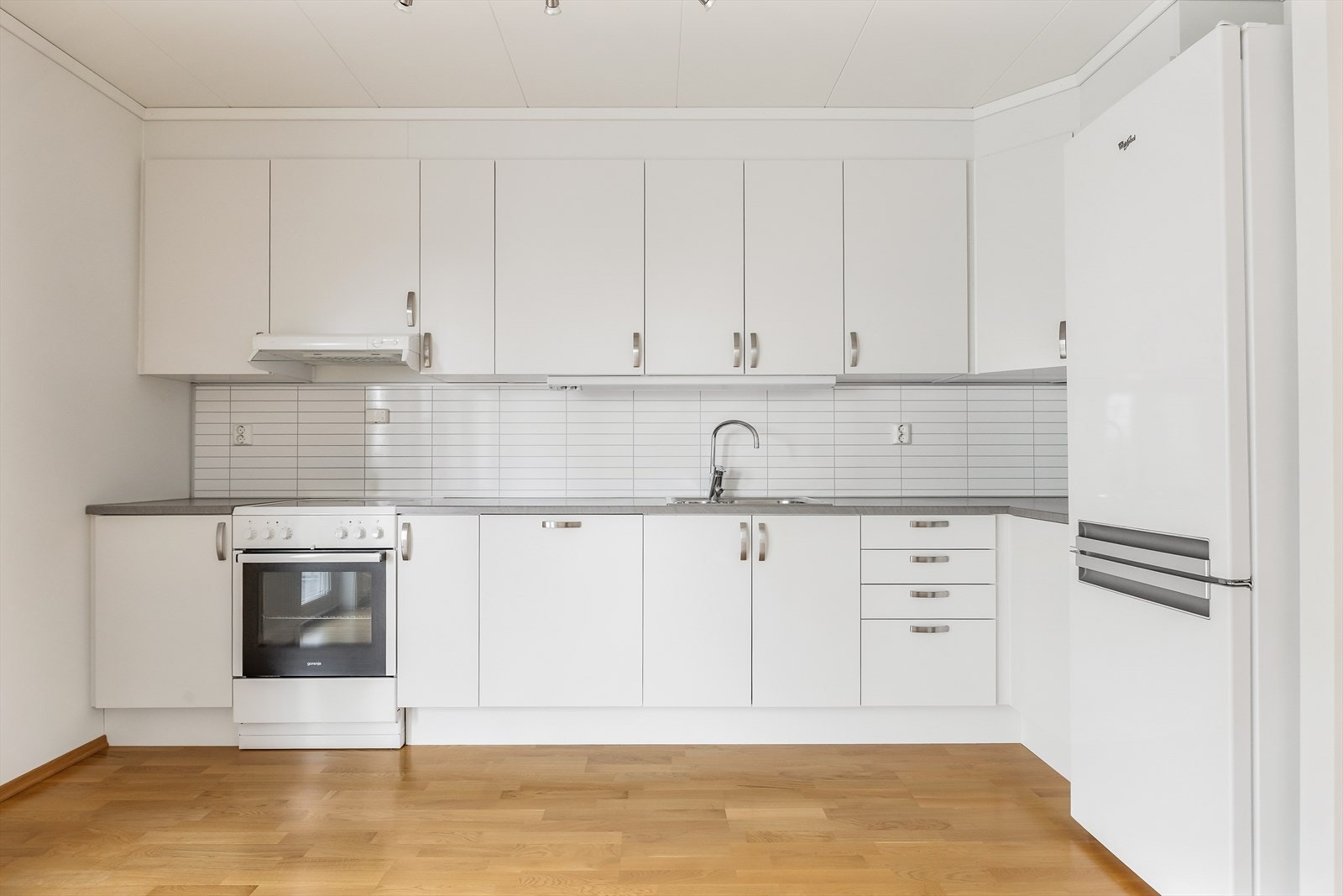 Kjøkkenet har hvite, glatte fronter, laminat benkeplate og integrert oppvaskmaskin. Galleribilde