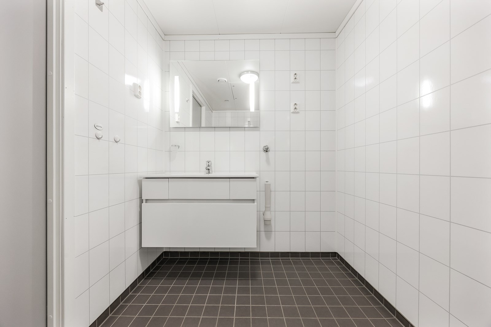 Badet har elektrisk gulvvarme og er innredet med en servantseksjon med skuffer og speil med belysning. Galleribilde