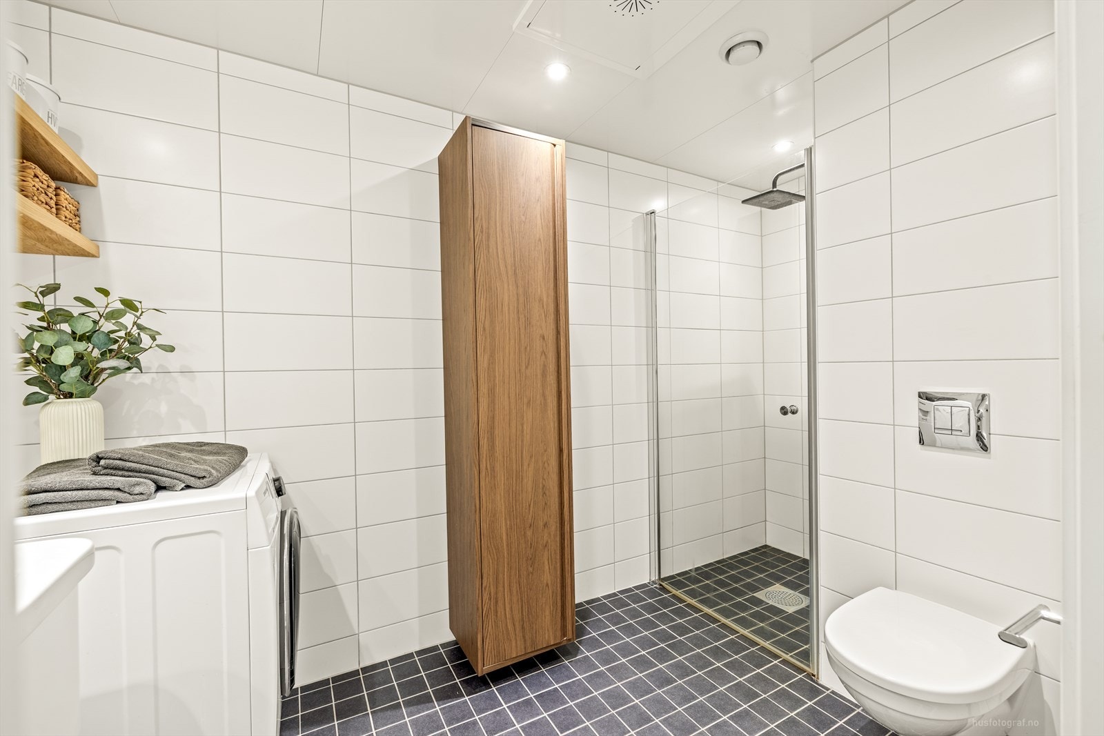 Baderomsinnredning i hvit utførelse med servant og rom for oppbevaring i skuffeseksjon og speil. Galleribilde