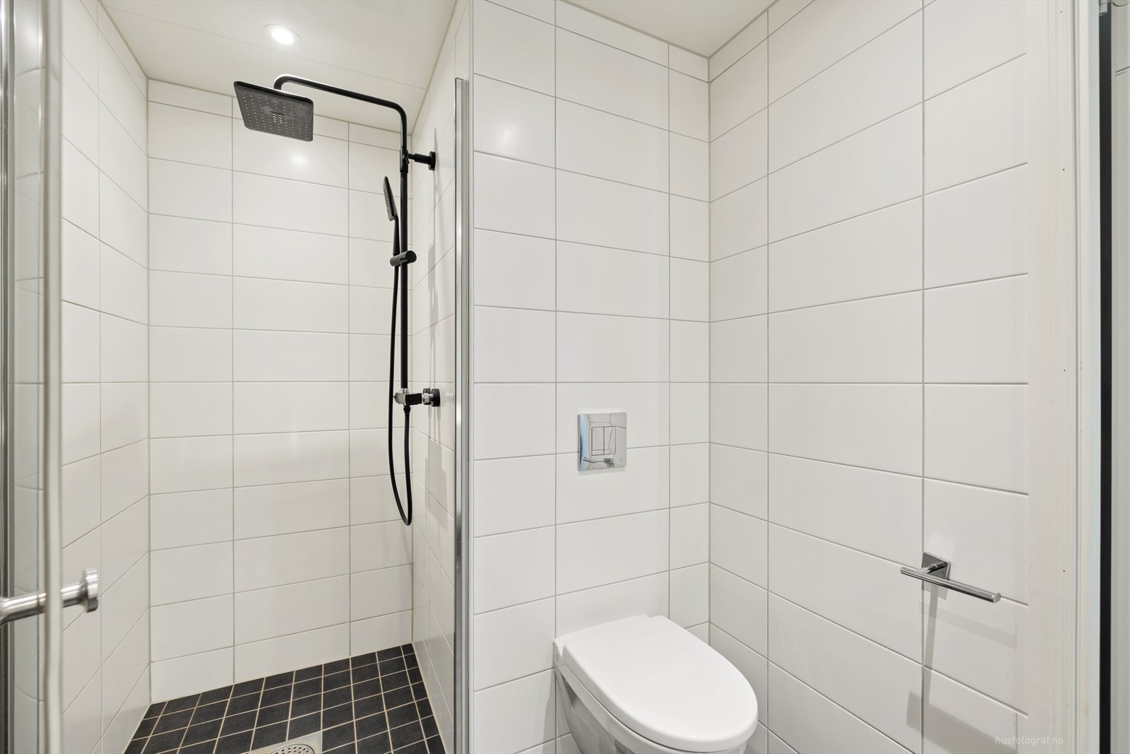 Videre er badet utstyrt med dusjhjørne med innfellbar dusj dør, vegghengt toalett og det er opplegg for vaskemaskin. Galleribilde