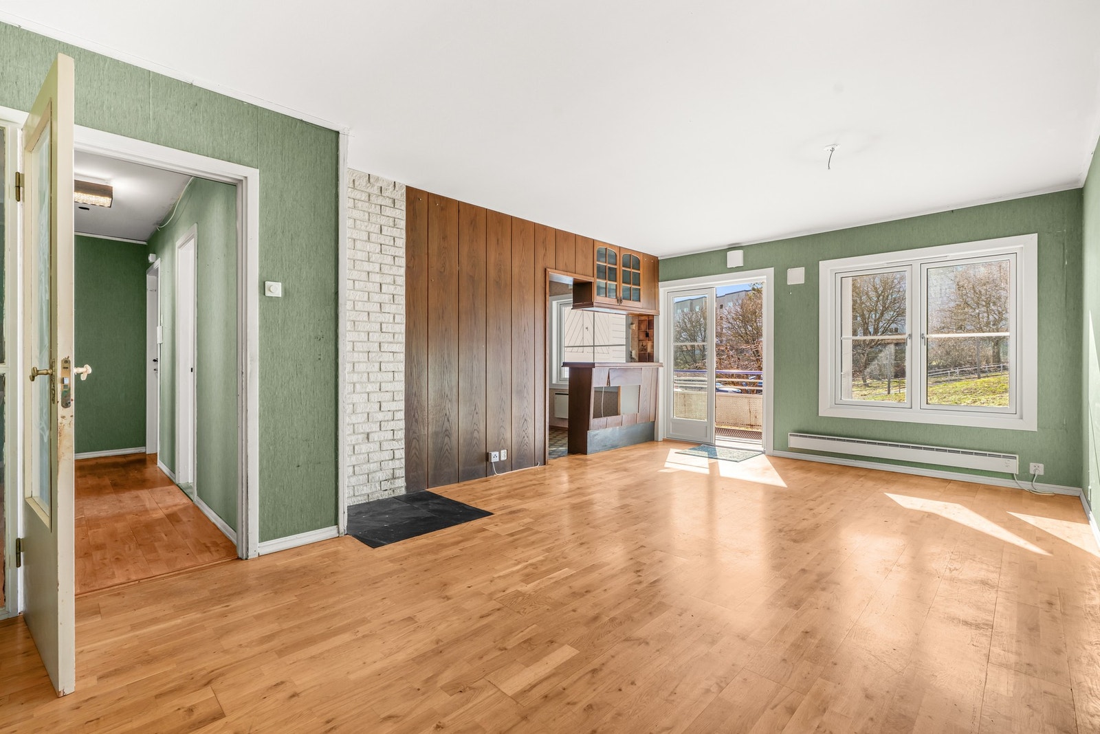 Stuen er lys med stort sydvestvendt vindu og utgang til en overbygd balkong via en tofløyet terrassedør. Galleribilde