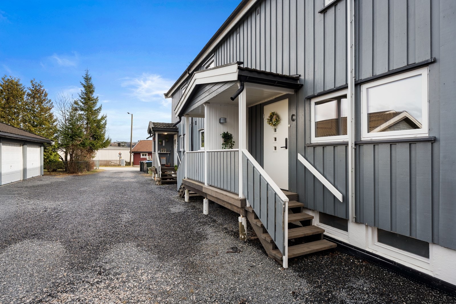 Overbygget inngangsparti med malt tredør med glassfelt. Galleribilde