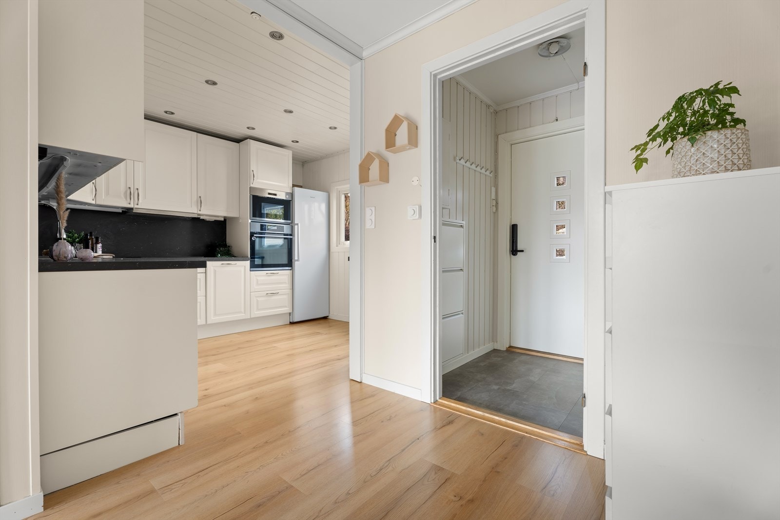 Kjøkkenet har hvite, profilerte fronter og godt med skap- og benkeplass. Galleribilde