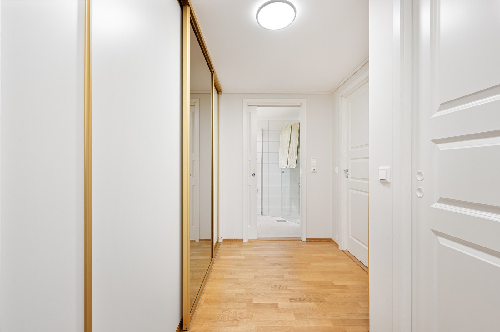 Gang mellom bad og soverom, med en svært romslig skyvedørsgarderobe. Her har man massevis av oppbevaringsplass. Leiligheten har også en ekstern bod i kjeller for ytterligere oppbevaringsplass. Galleribilde
