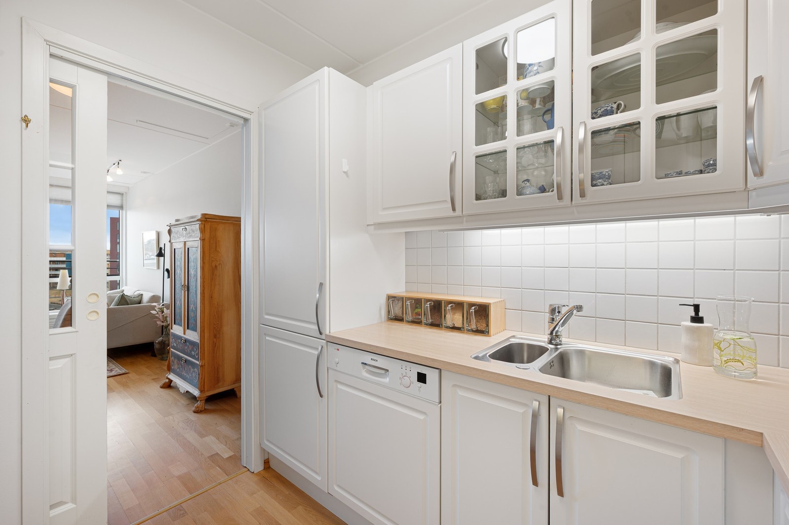 Flislagt mellom benkeplate og overskap på kjøkkenet. Gjennomgående lyst og pent i hele leiligheten. Galleribilde