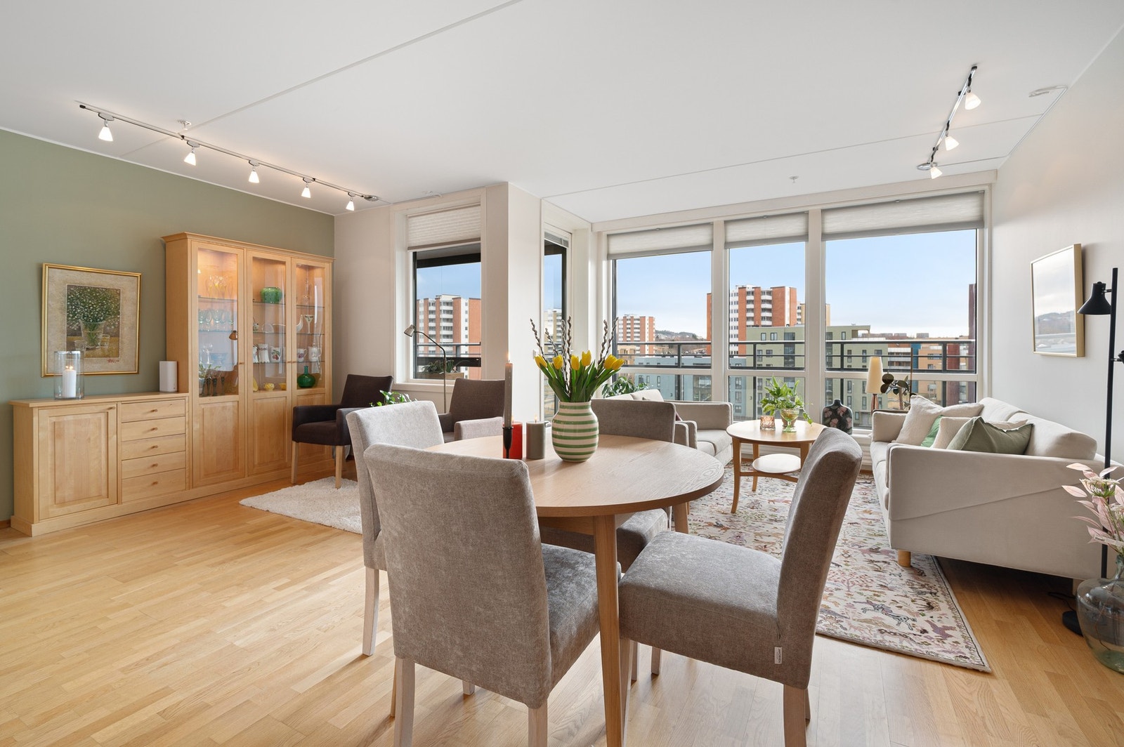 Mellom stua og kjøkkenet er det også plass til en spisegruppe. Alternativt kan man også ha en større spisegruppe til venstre i bildet, der vitrineskap/skap står plassert i dag. Galleribilde