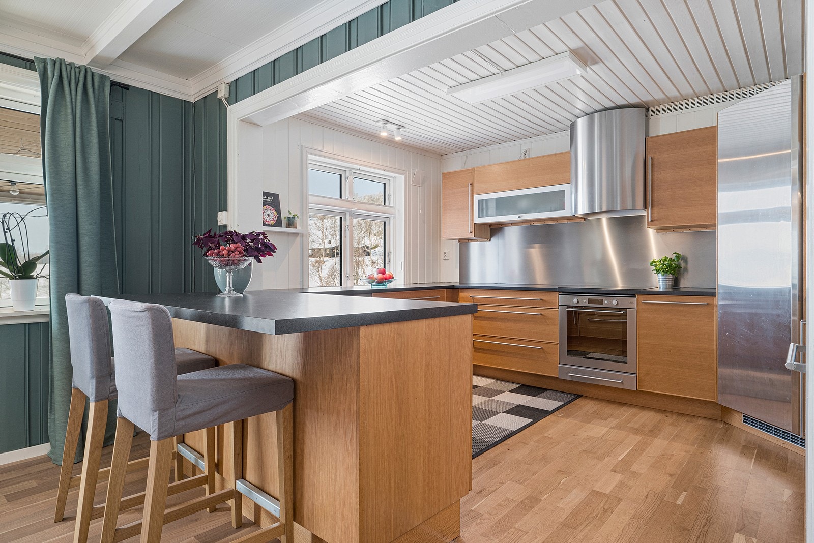 Kjøkkenet har integrerte hvitevarer, kjølehjørne og vinskap. Galleribilde