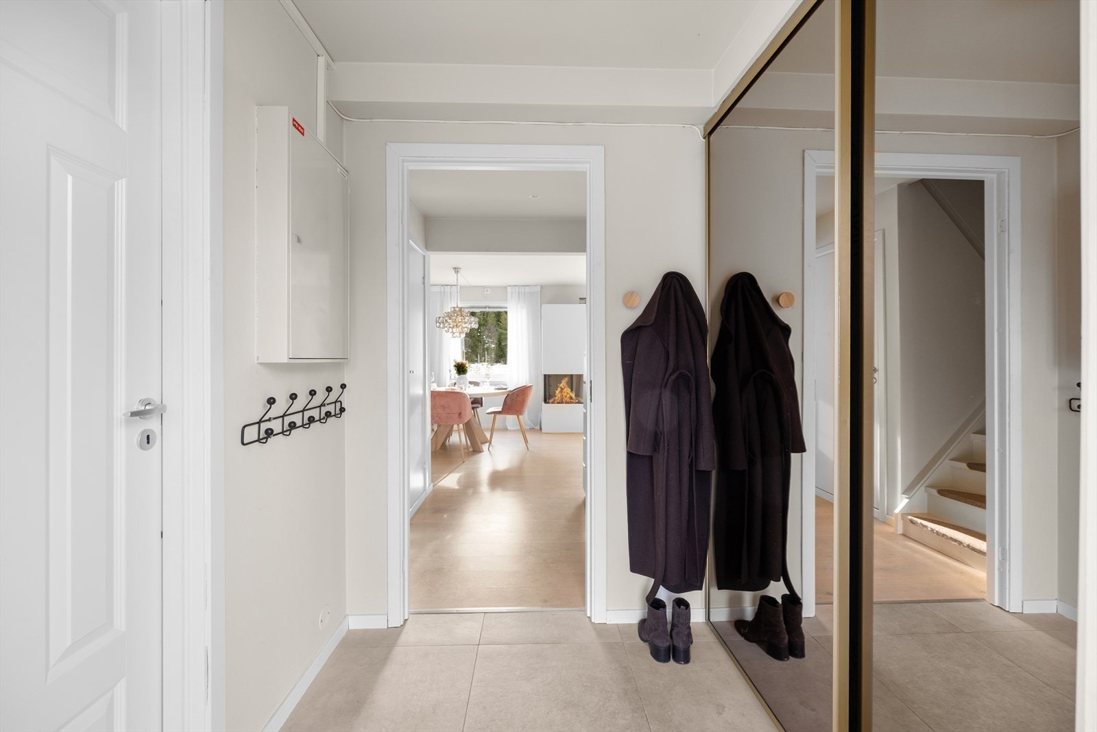 Romslig og praktisk entré med skyvedørsgarderobe for oppbevaring av yttertøy og sko. Rommet har fliser og elektriske varmekabler på gulv. Galleribilde