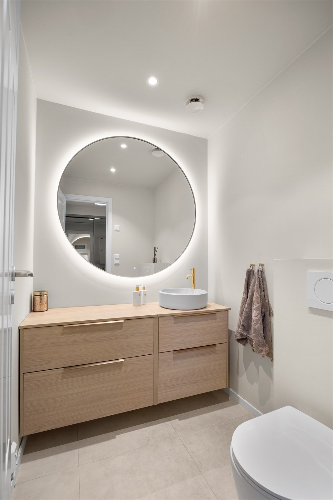 Toalettrom pusset opp i 2024 med fliser på gulv, malte plater på vegg i tak. Rommet er utstyrt med vegghengt toalett og skuffer med servant. Stort speil med belysning. Galleribilde