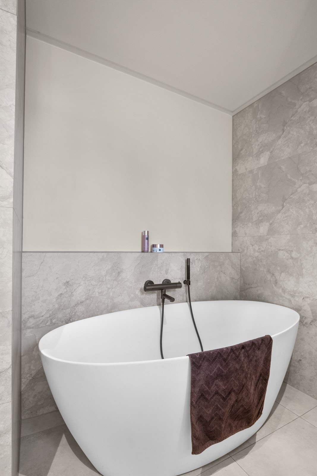 Badet er utstyrt med innredning med servant, veggmontert toalett, badekar med Tapwell blandebatteri og dusjhjørne med dusjvegg og regnfallsdusj. Galleribilde