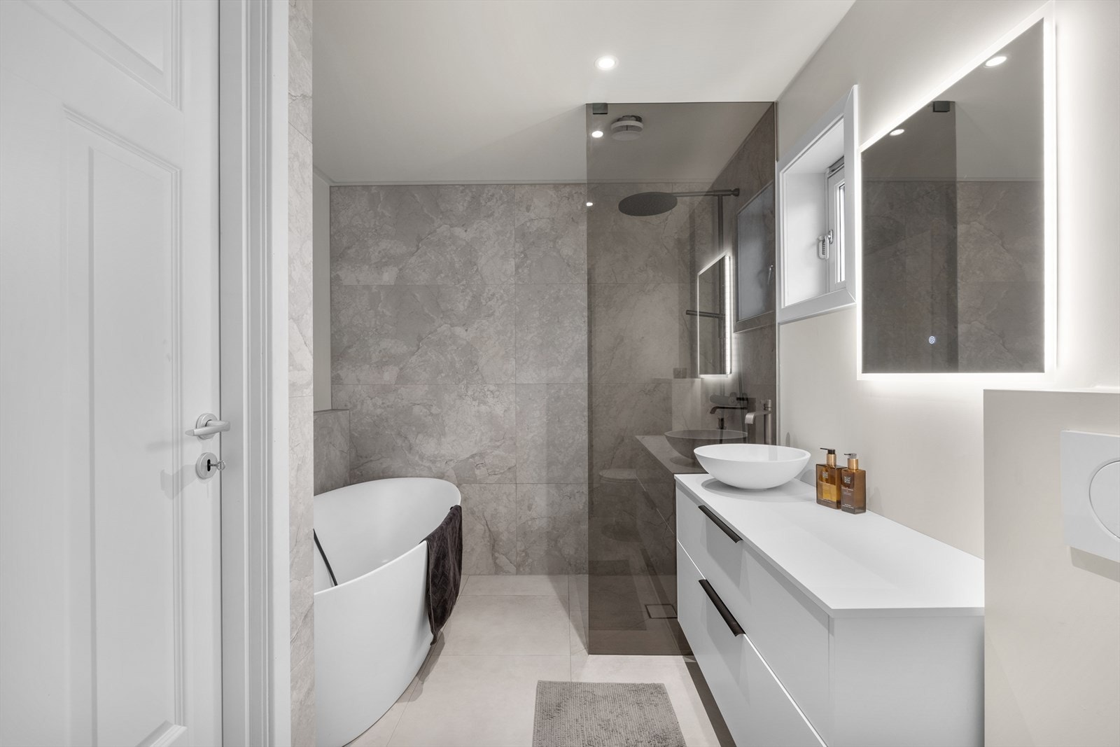 Delikat og påkostet baderom med elektriske varmekabler i gulv. Veggene har fliser og taket er malt med innfelte downlights. Galleribilde