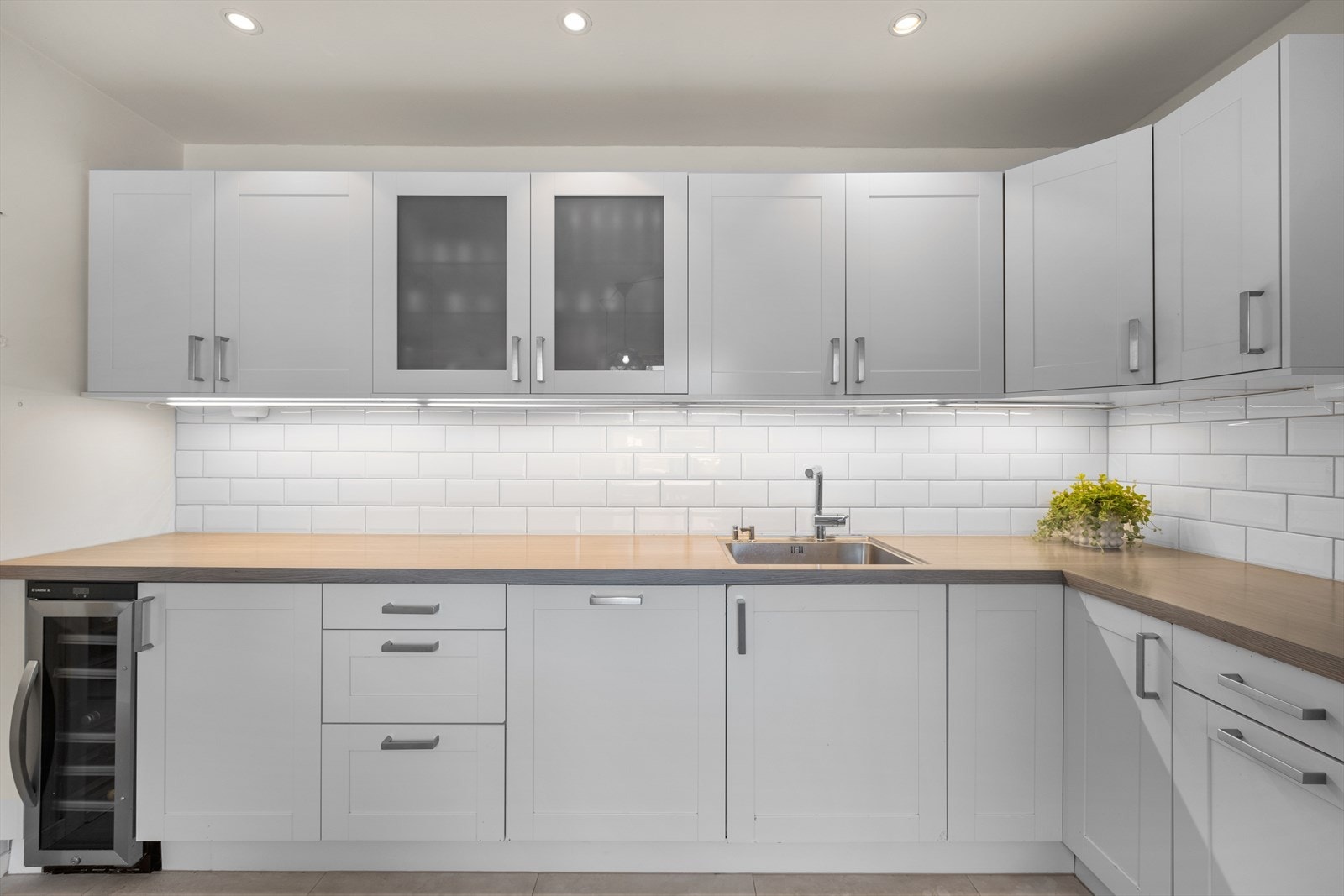 Kjøkkeninnredning med profilerte fronter. Benkeplate i laminat og oppvaskkum i stål med ett greps blandebatteri. Videre har kjøkkenet koketopp med ventilasjon, stekeovn, microovn, oppvaskmaskin, kjøleskap/fryseskap og vinskap. Galleribilde