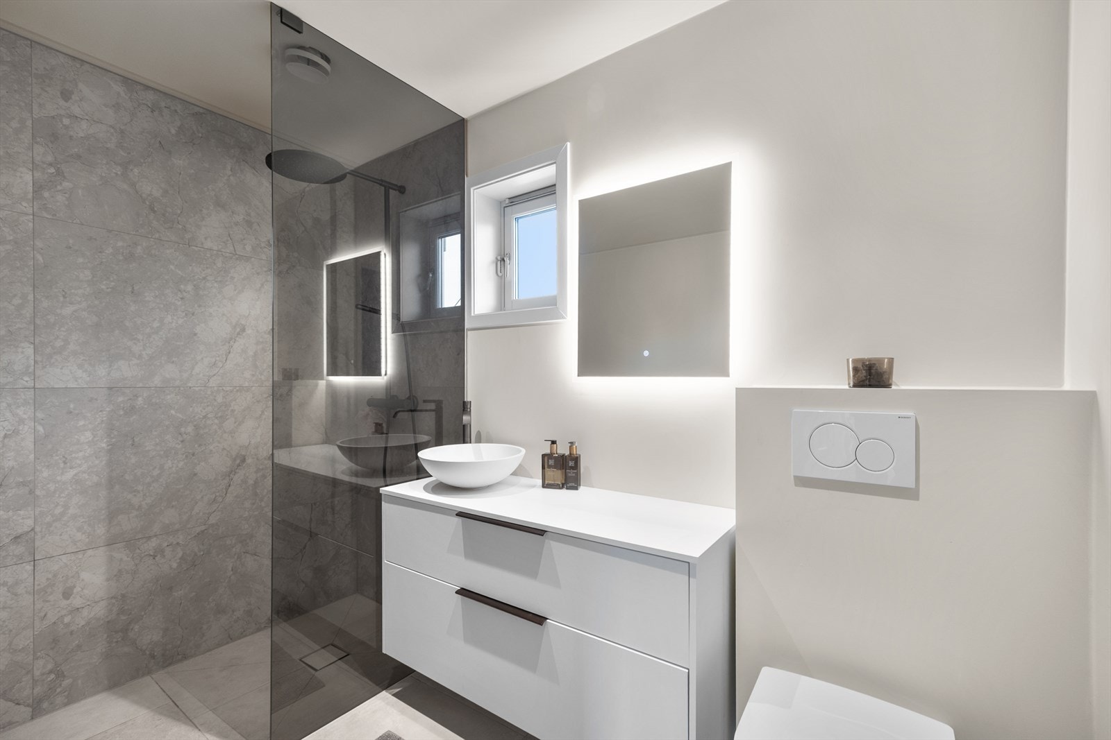 Badet er utstyrt med innredning med servant, veggmontert toalett, badekar med Tapwell blandebatteri og dusjhjørne med dusjvegg og regnfallsdusj. Galleribilde