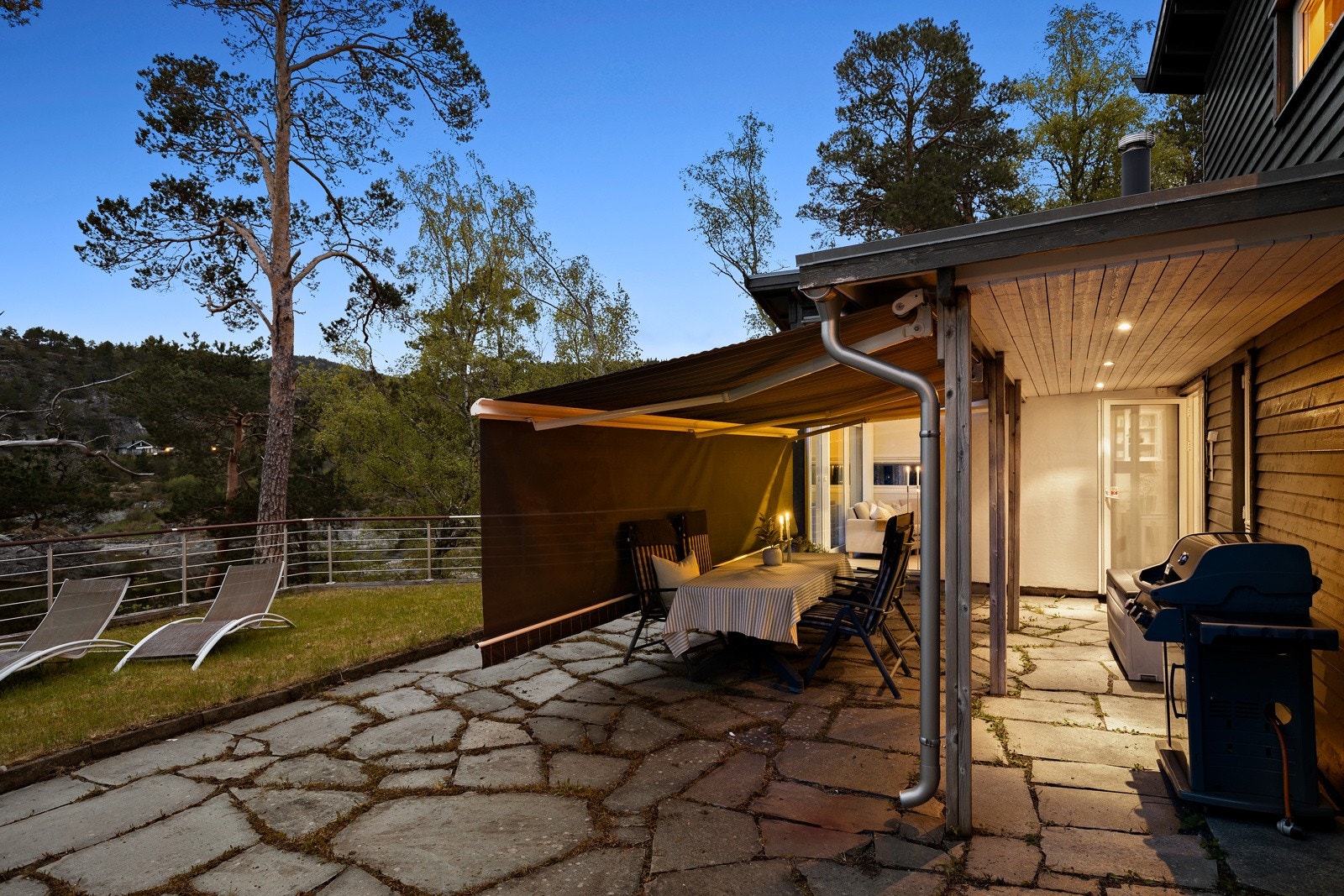 Takoverbygd markterrasse med skiferheller og elektrisk markise som forlenger "rommet". Galleribilde