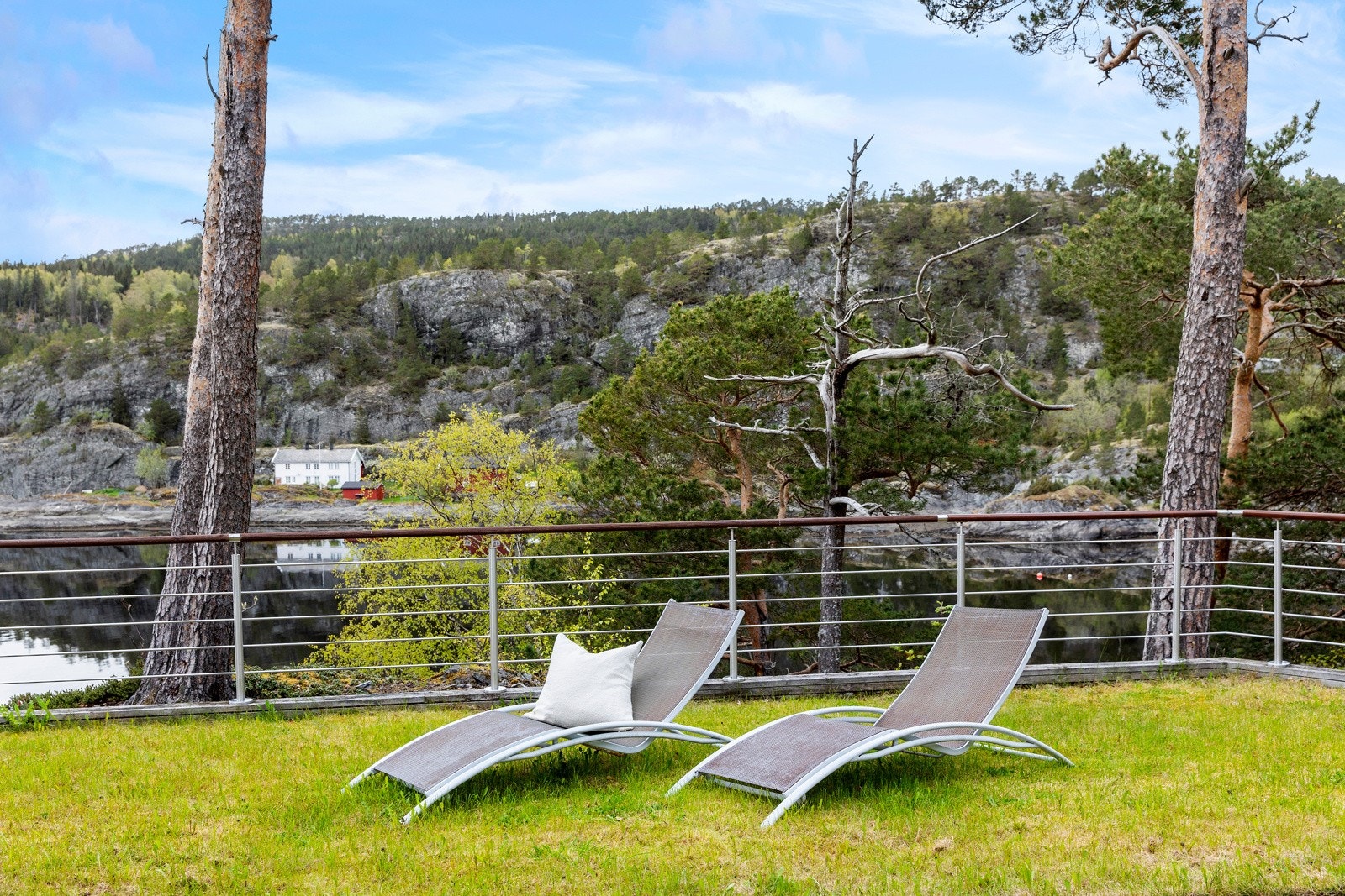 Det er installert up-light-belysning mot flere av de vakre furutrærne som omkranser eiendommen. Galleribilde