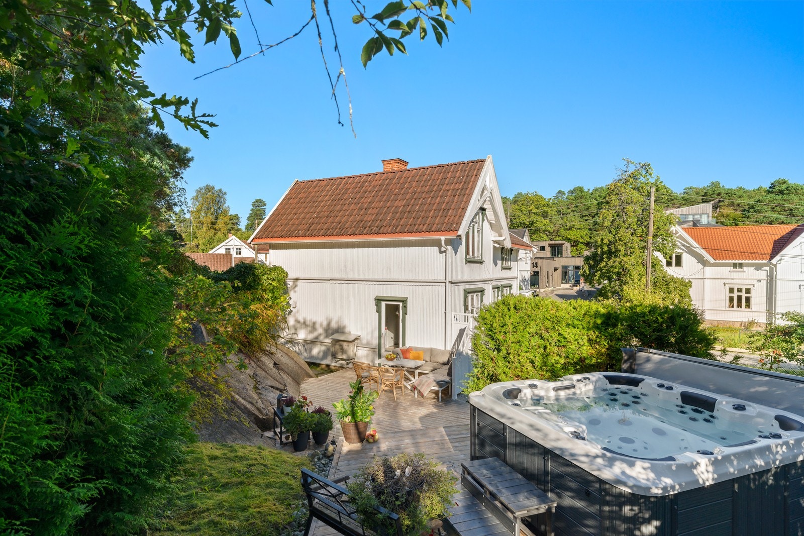 Eneboligen har en romslig hage og terrasseløsning. Utendørs boblebad ligger godt skjermet og integrert i terrassen. Galleribilde