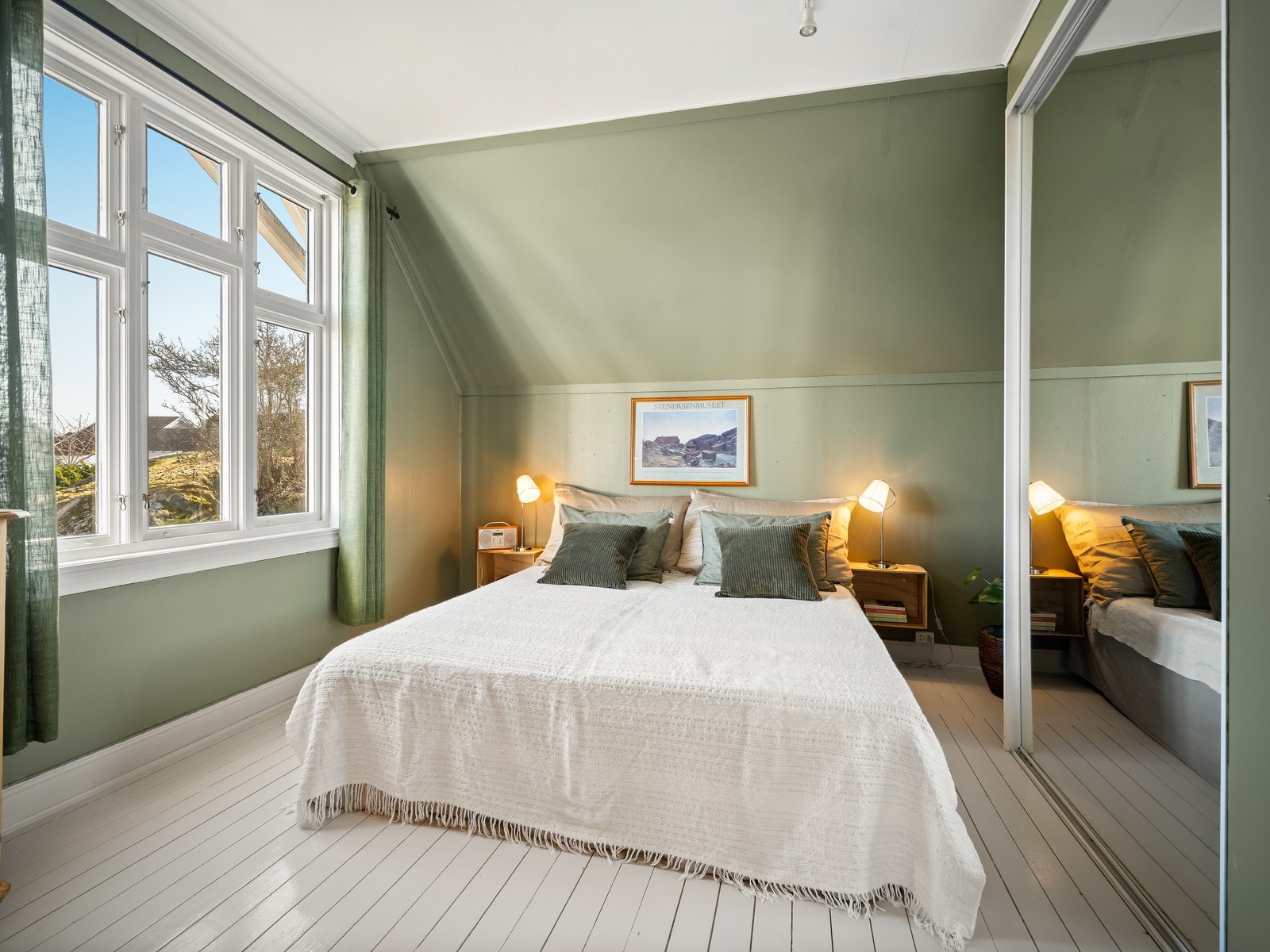 Hovedsoverommet har god plass til dobbeltseng og oppbevaring. Legg merke til de malte gulvplankene. Fra vinduet er det utsikt til Gamlebyen og Fredrikstad-broen. Galleribilde