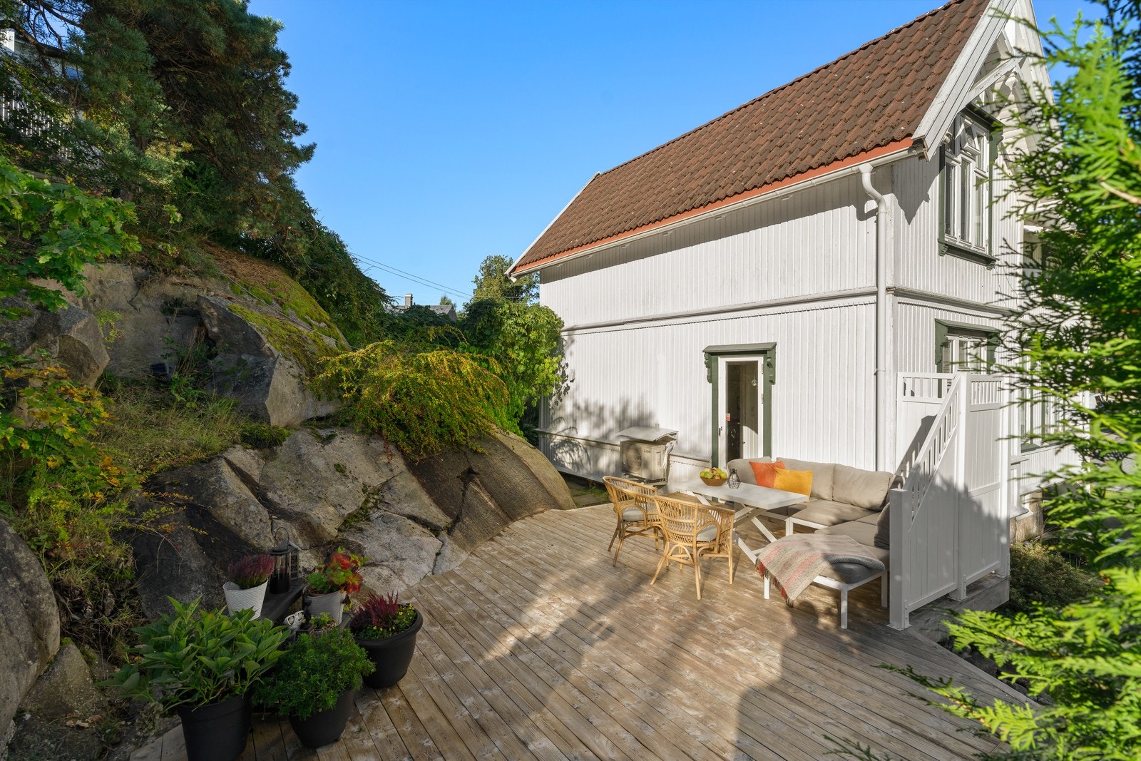 Eiendommen har en fin terrasse som ligger skjermet på baksiden av huset og er tilpasset naturtomten. Galleribilde