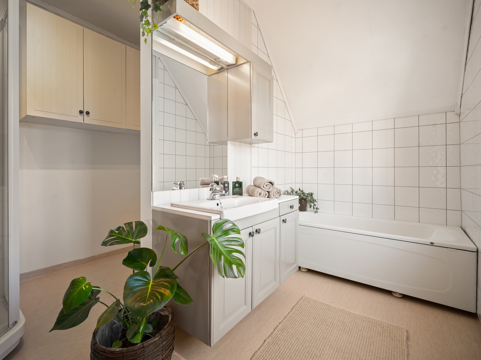 Rommet har en innredning med nedfelt servant med underskap, speil og overskap. Galleribilde