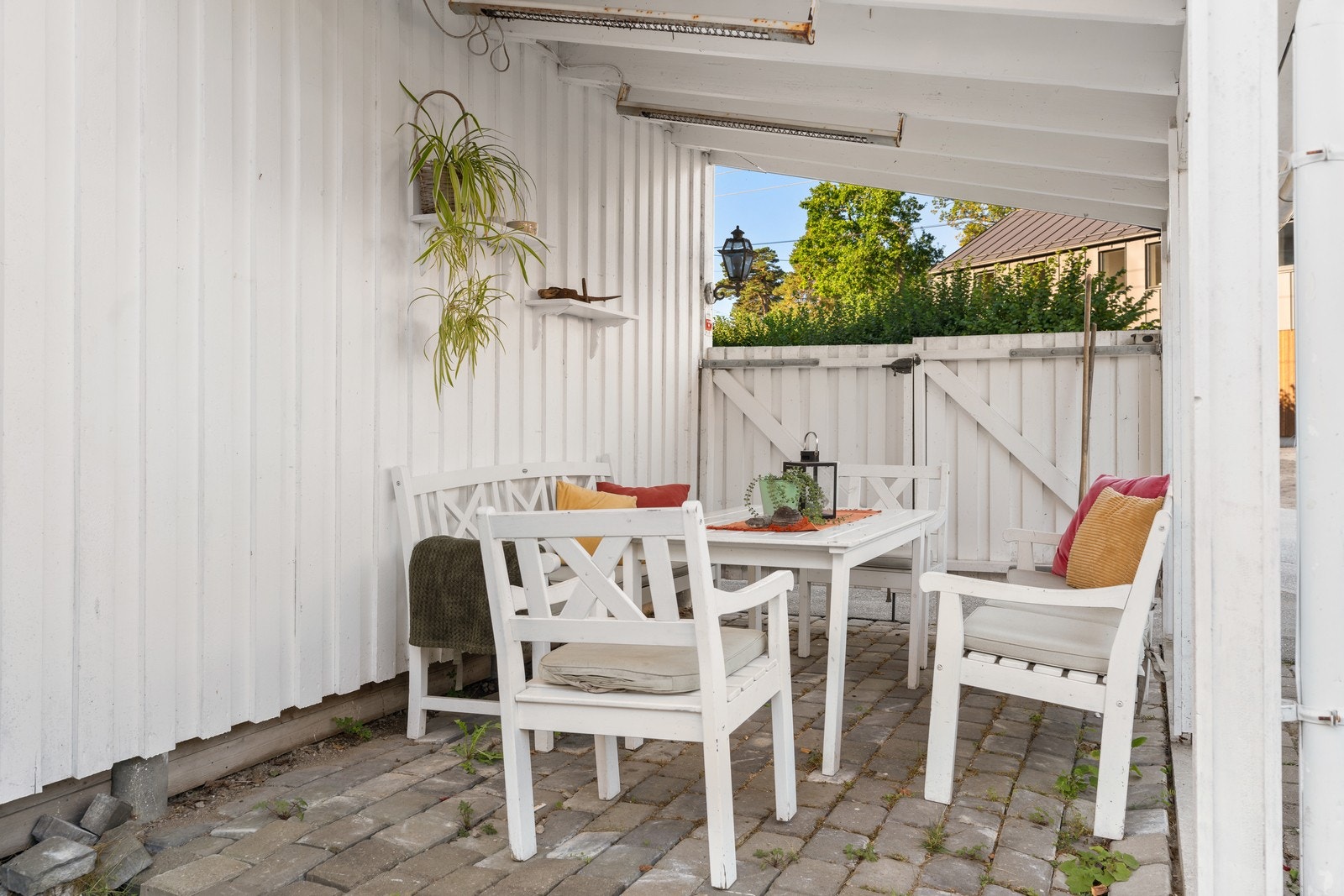 I carporten er det laget en overbygd uteplass med steinlagt underlag. Her er det varmelamper som innbyr til gode stunder i allslags vær. Galleribilde