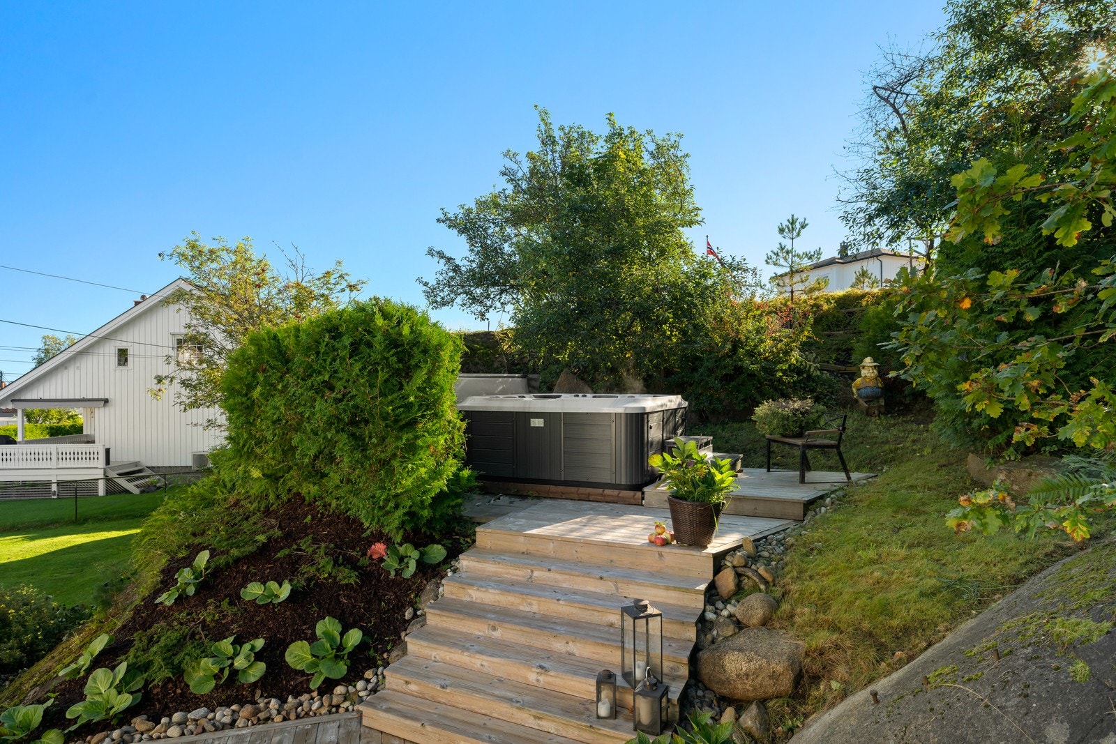 Tomten er pent opparbeidet med gressplen, hekker, trær og beplantning. Galleribilde