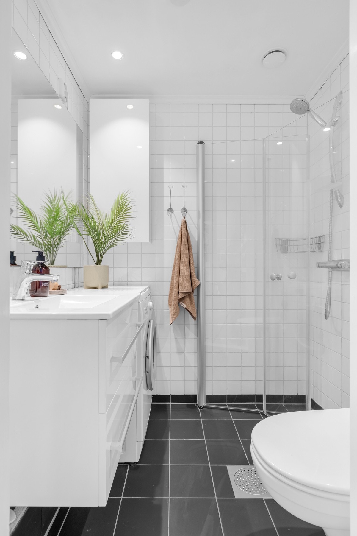 Badet er utstyrt med veggmontert servantinnredning, toalett og opplegg for vaskemaskin. Galleribilde