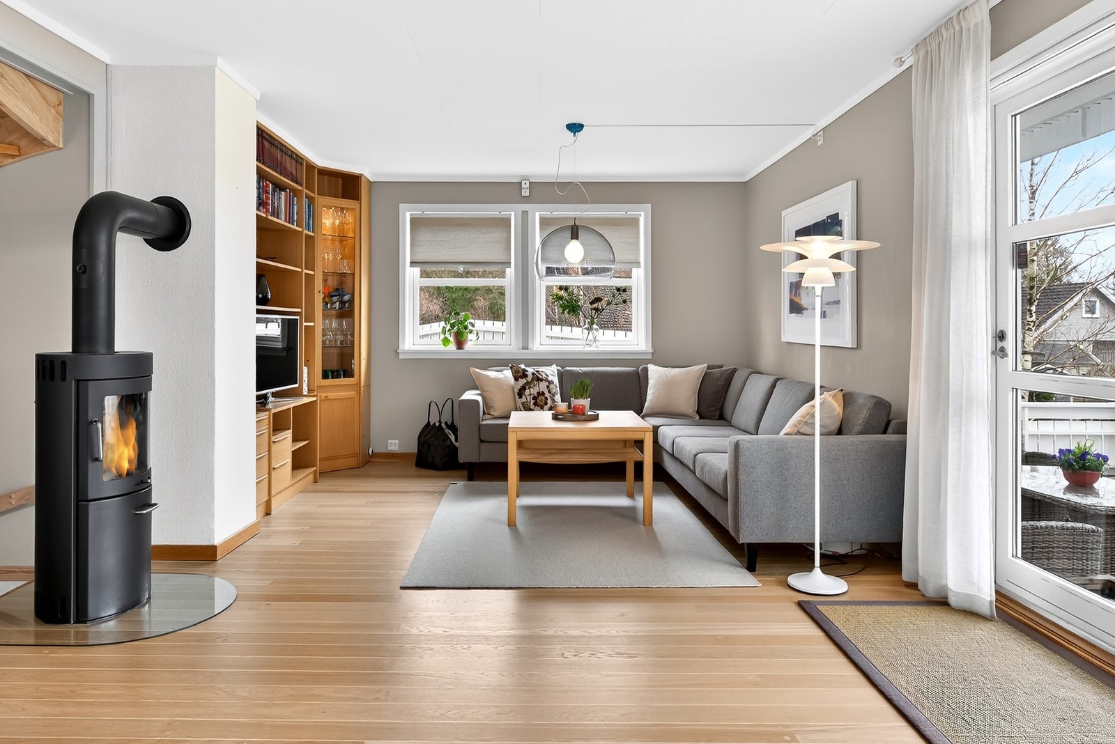 Stuen har en hyggelig planløsning og vedovn som skaper lun stemning Galleribilde