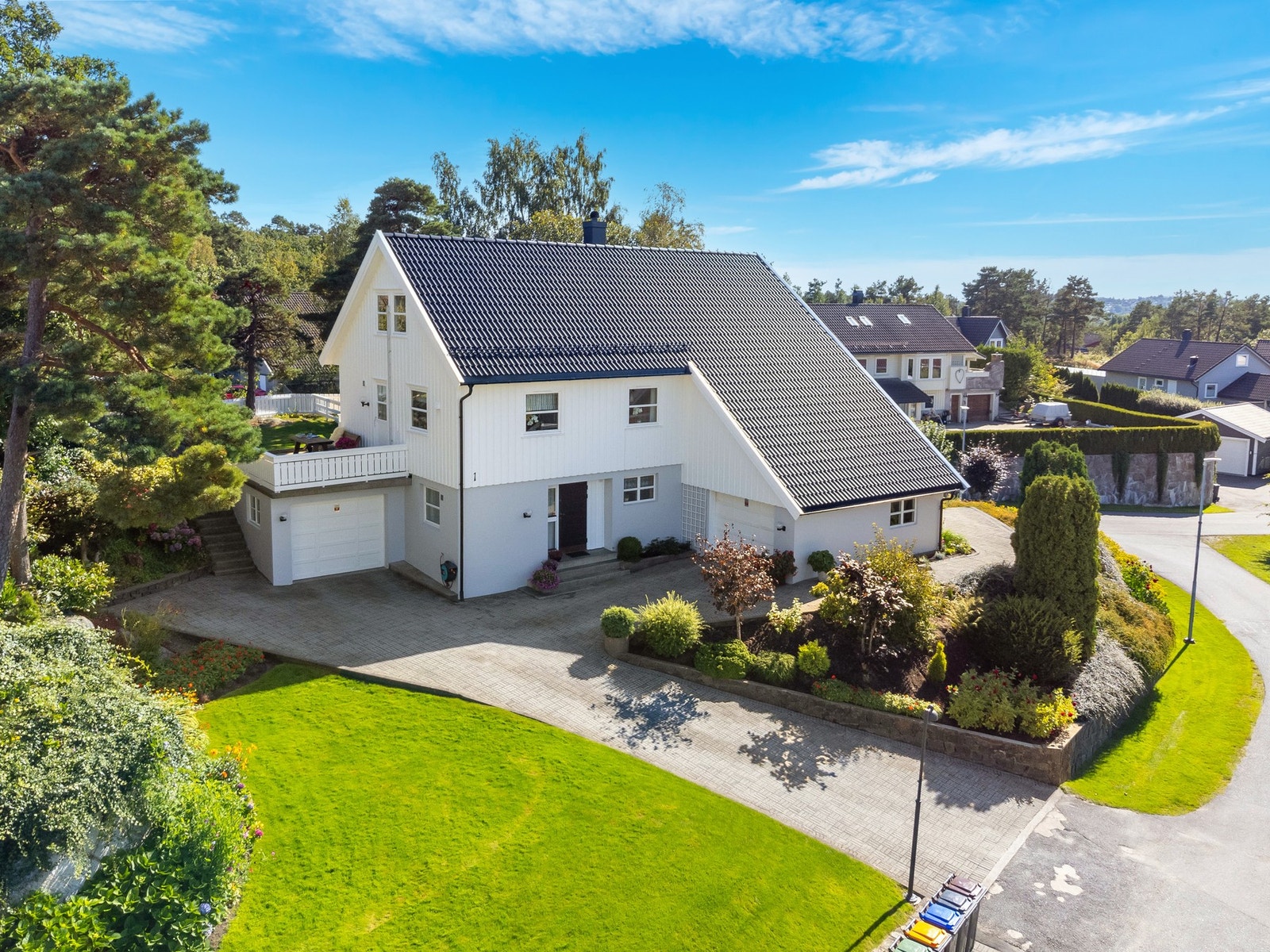 Romslig tomt med pent opparbeidet hage og gode parkeringsmuligheter. Det er i dag etablert smijernsrekkverk på muren. Galleribilde