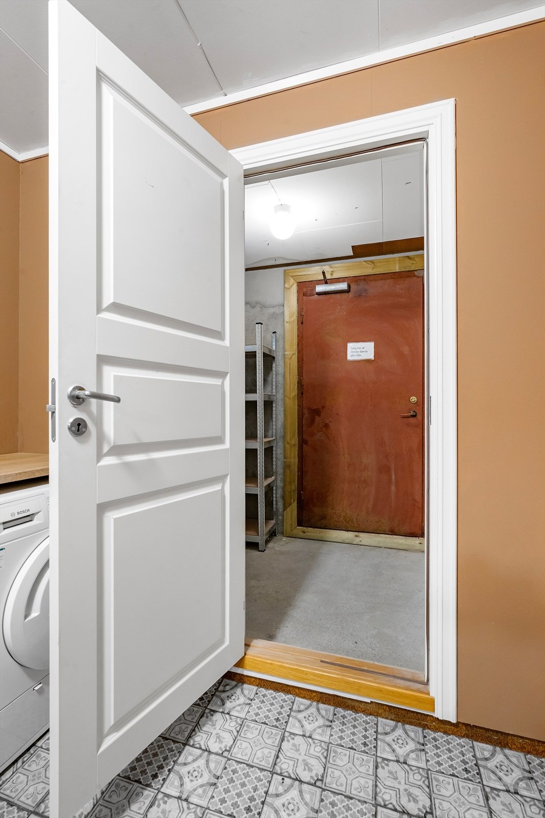 Dør fra vaskerommet leder til bod med betonggulv, og dør videre til garasjen. Galleribilde