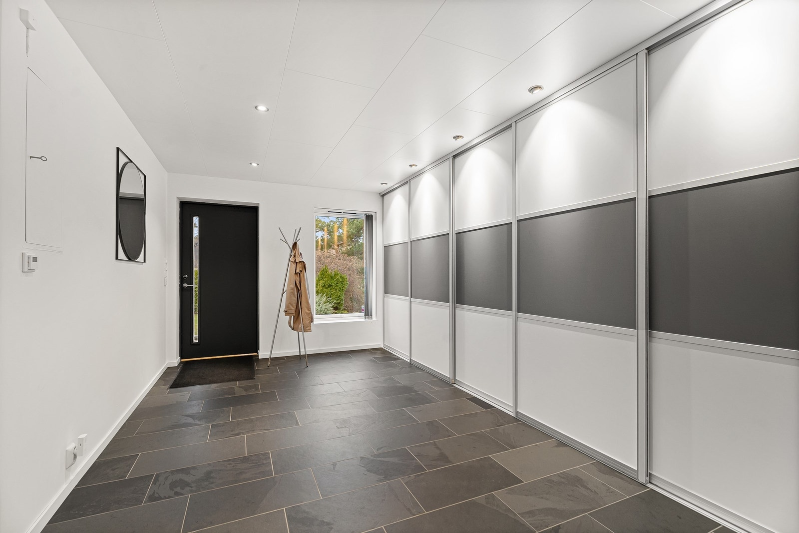 Innbydende og romslig entre med Langlo skyvedørsgraderobe med Elfa garderobesystem. Galleribilde