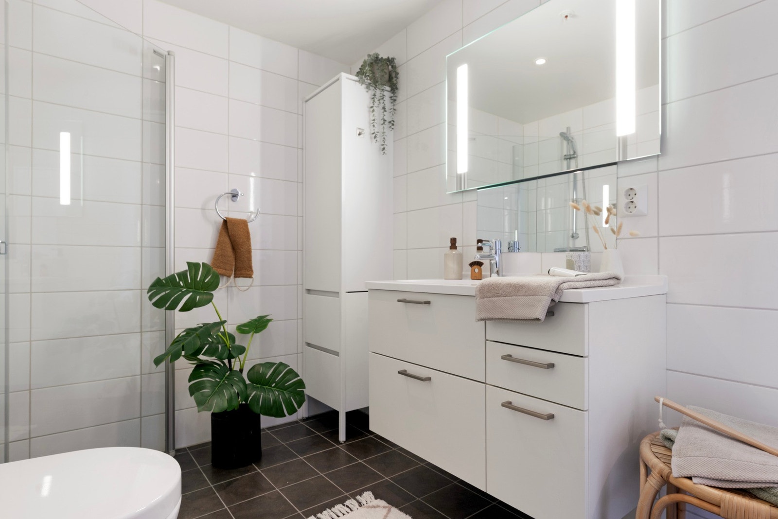 Innfellbare dusjvegger, innredning med god skap og skuffeplass samt speil med innfelt belysning Galleribilde