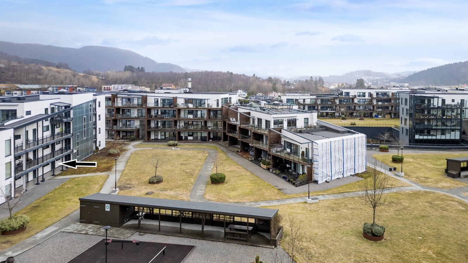 Leiligheten er beliggende ved koselig boligtun med felles takhage med gangstier og belysning samt plen og beplantning Galleribilde