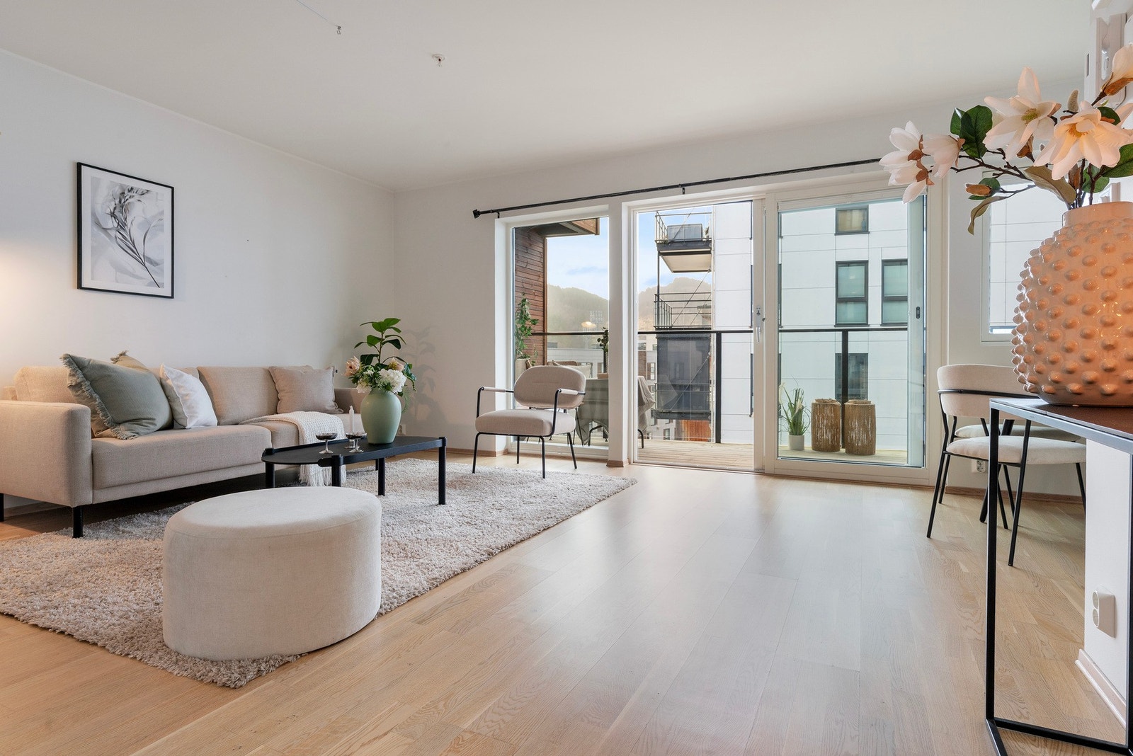 Lys og innbydende stue med fint parkettgulv og store vindusflater Galleribilde