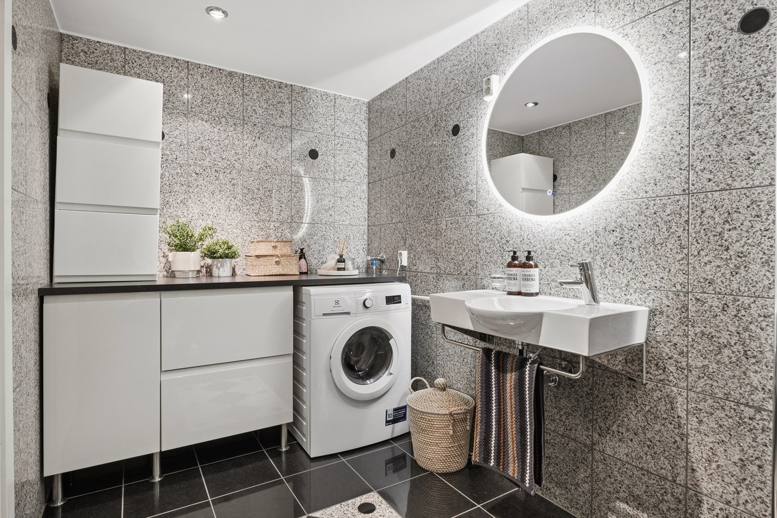 Rommet har flislagte overflater, vegghengt toalett og dusjhjørne med innfellbare glassdører. Galleribilde