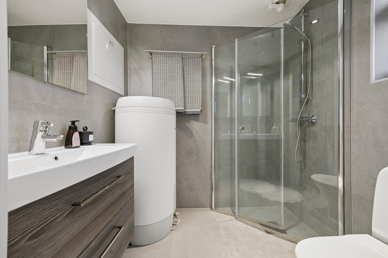 Badet på loftet ble totalrenovert i 2023, med delikate fliser, moderne innredning og sensorstyrt mekanisk avtrekk. Galleribilde