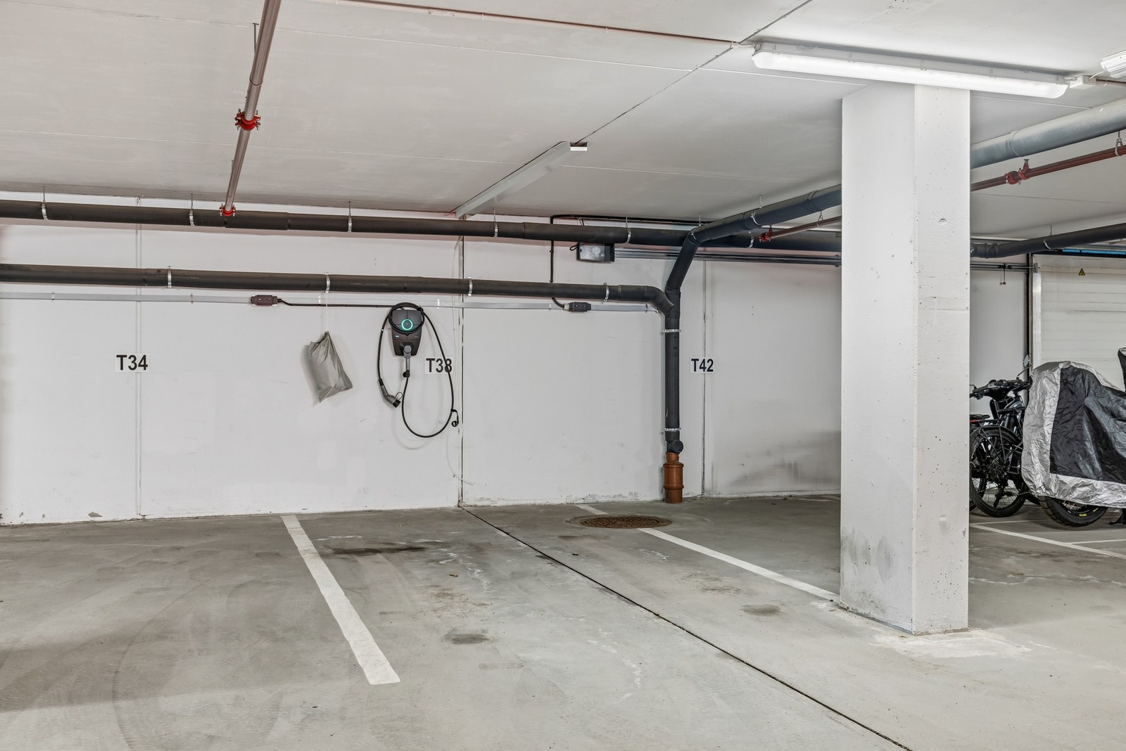 Biloppstillingsplass med elbillader i parkeringskjeller merket nr 38. Galleribilde
