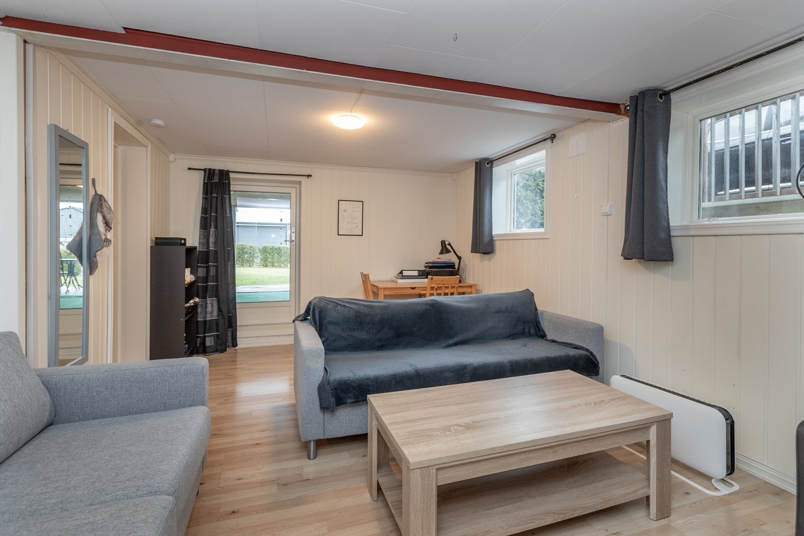 Vegger med MDF-panel og laminatgulv gir et praktisk og vedlikeholdsvennlig interiør. Galleribilde