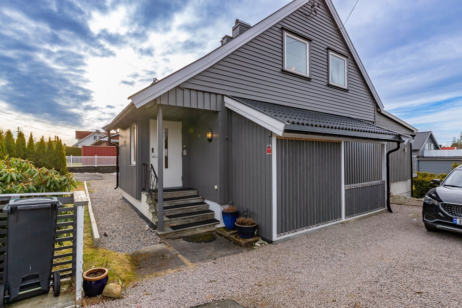 Huset har en utvendig trekledning med liggende panel og betongtakstein på taket. Galleribilde