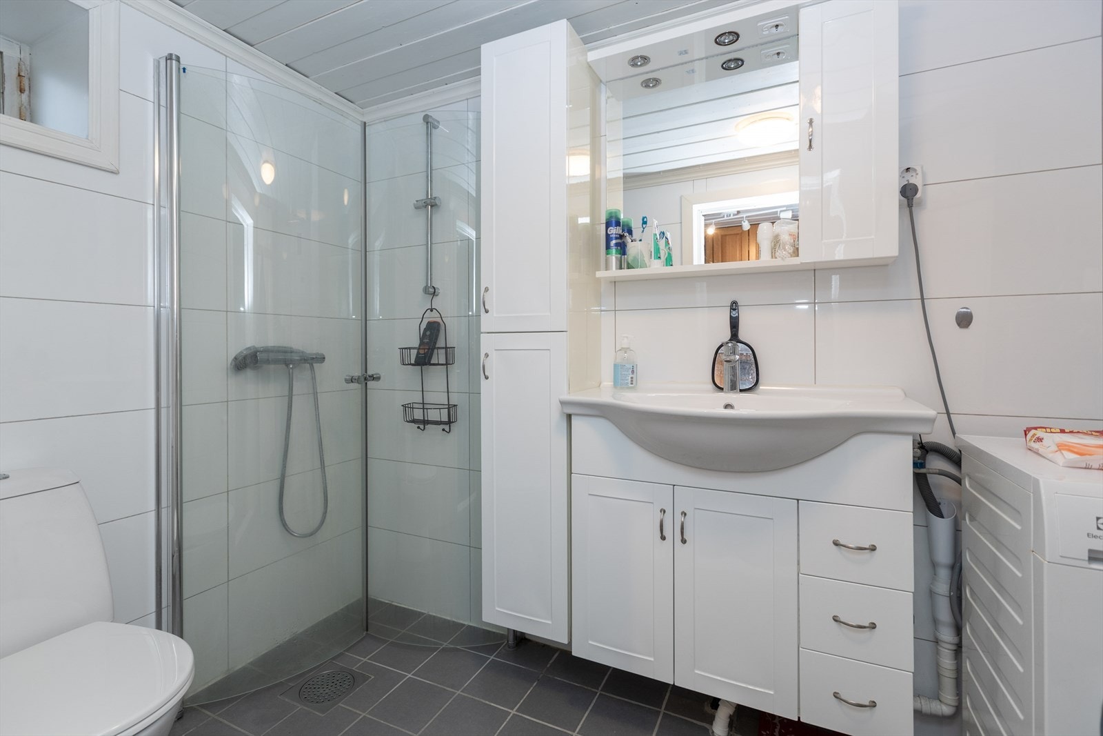 Keramiske fliser på gulv og mekanisk ventilasjon sikrer et funksjonelt våtrom. Galleribilde