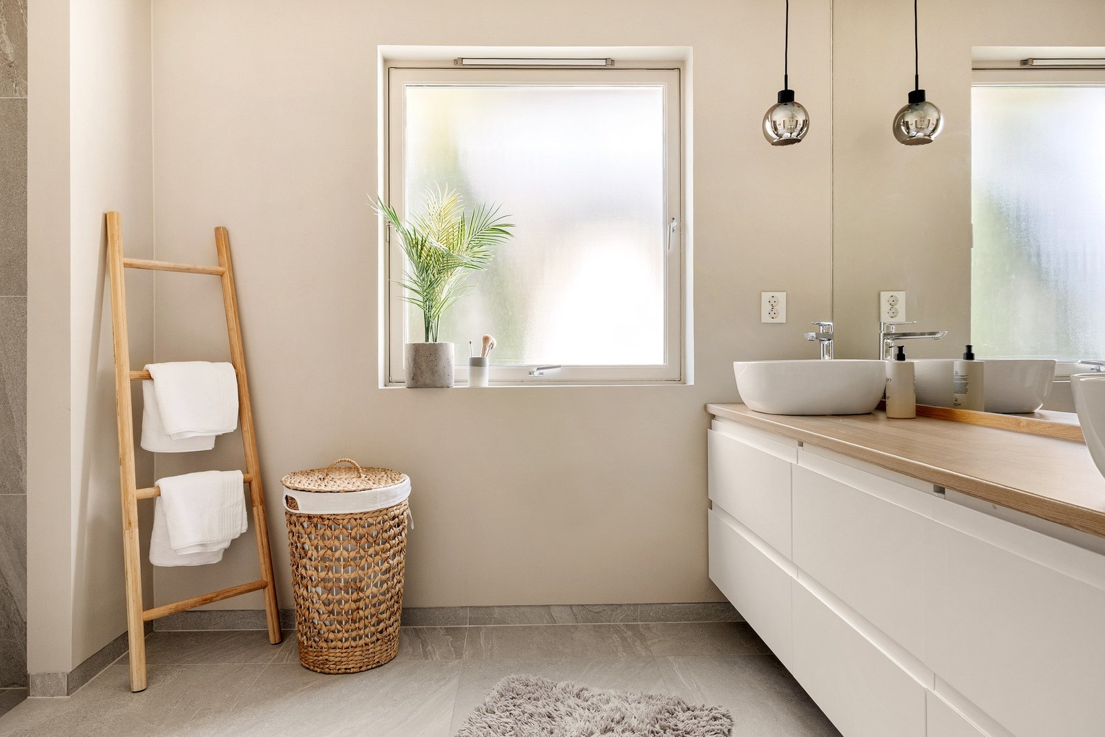 Badet har varmekabler i gulv, vegghengt toalett, dusjnisje, dobbelvask med underskap og et stort speil. Galleribilde