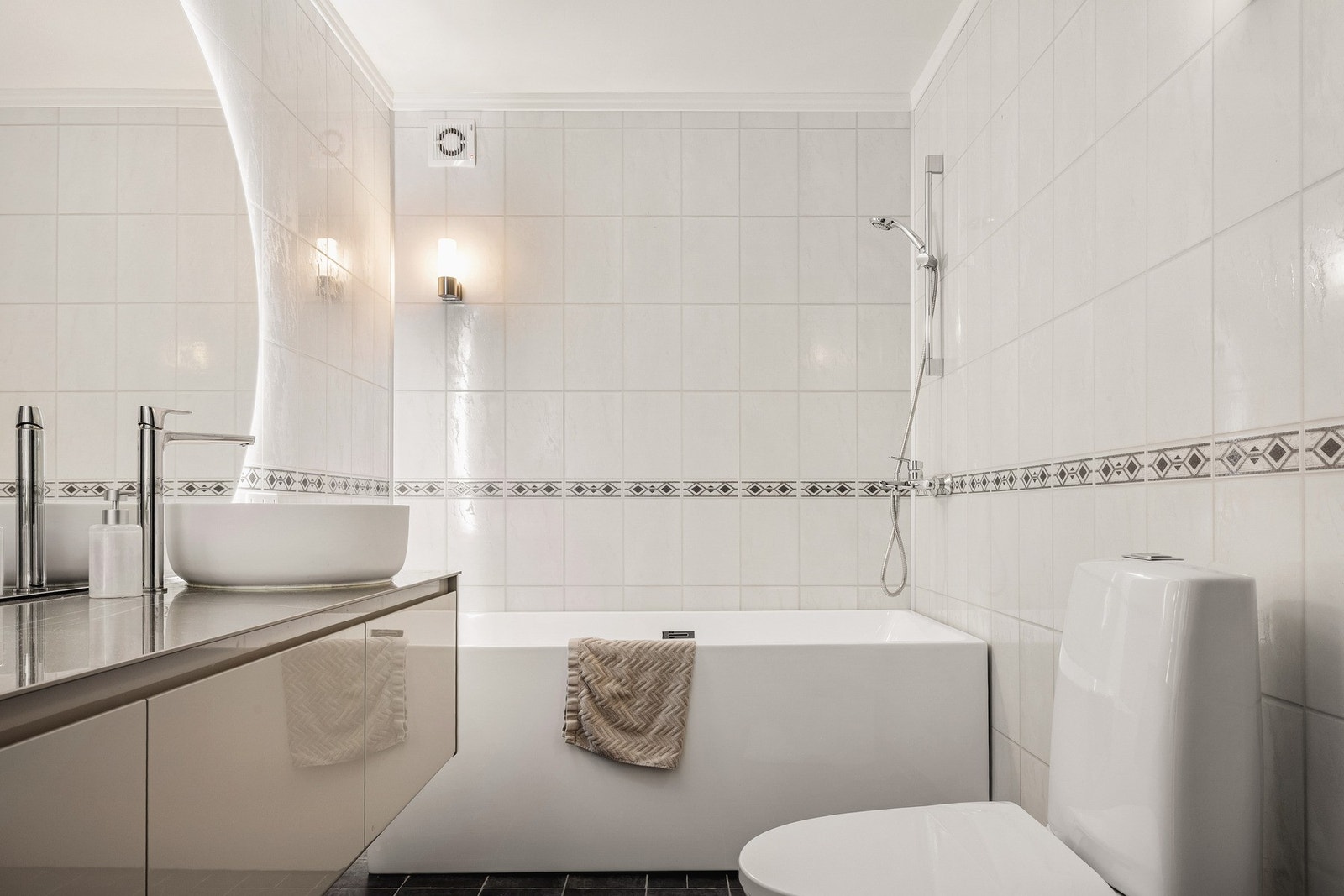 Badet har varmekabler i gulv, toalett, baderomsmøblement og et stort speil med lys. Galleribilde