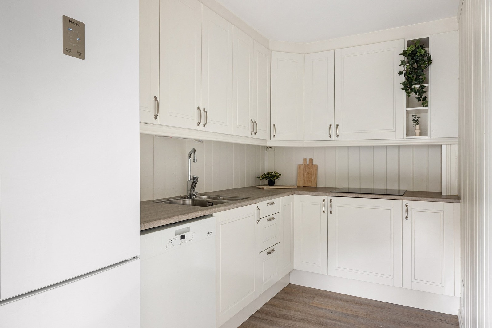 Kjøkkenet på 6 kvm har profilerte fronter og laminat benkeplate. Galleribilde